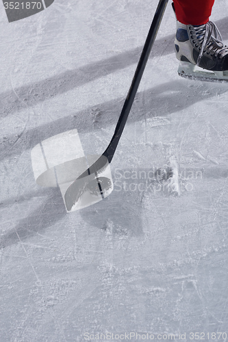 Image of hockey sticsk and puck on ice