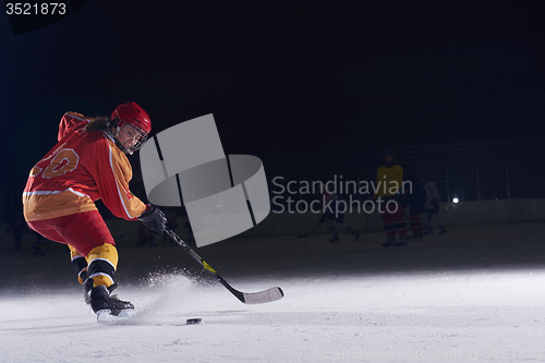 Image of teen ice hockey player in action