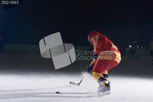 Image of teen ice hockey player in action