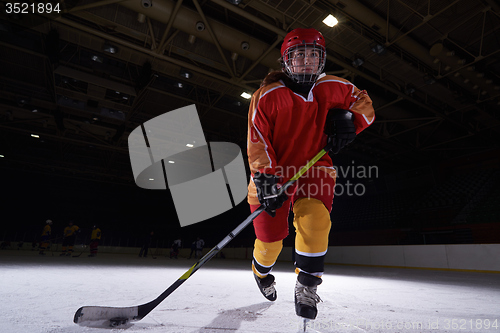 Image of teen ice hockey player in action