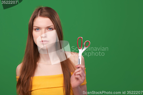 Image of Calm redhead woman holding scissors