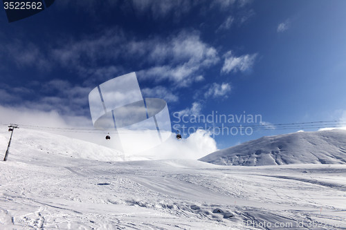 Image of Gondola lift and ski slope at sun day