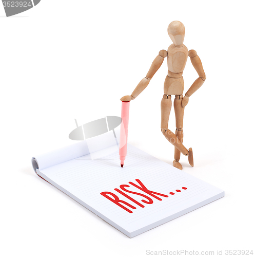 Image of Wooden mannequin writing - Risk