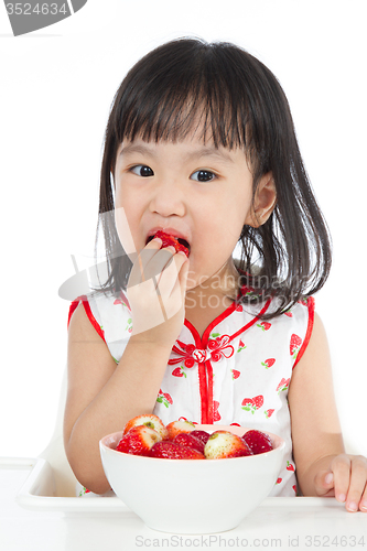 Image of Asian Chinese little girl eating strawberries