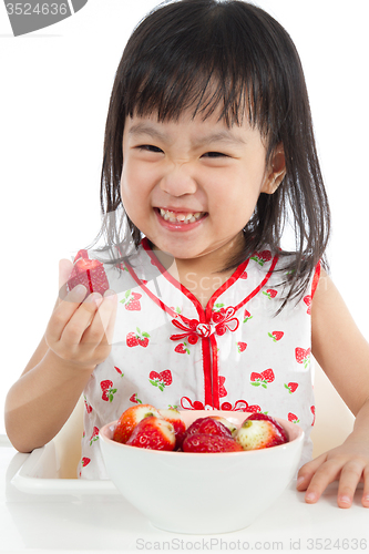 Image of Asian Chinese little girl eating strawberries