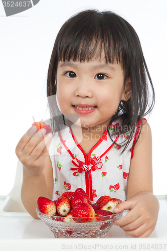 Image of Asian Chinese little girl eating strawberries