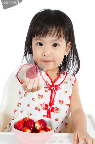 Image of Asian Chinese little girl eating strawberries