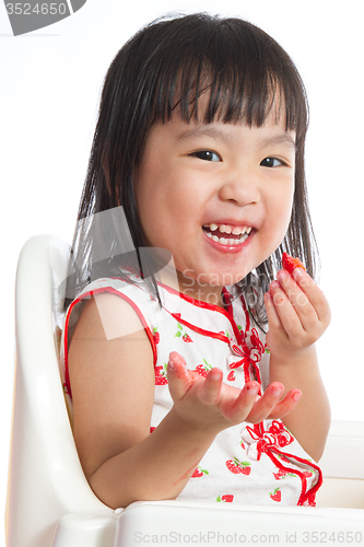 Image of Asian Chinese little girl eating strawberries