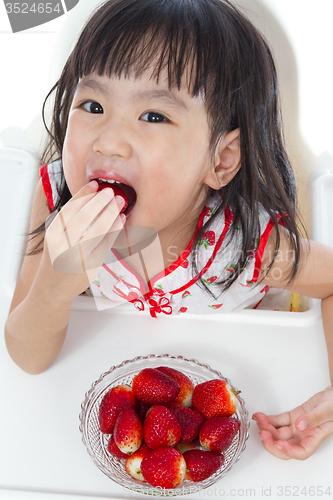 Image of Asian Chinese little girl eating strawberries