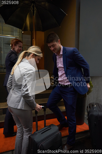 Image of business people couple entering  hotel