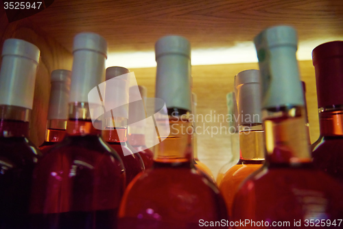 Image of Wine bottles on a wooden shelf.