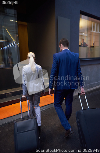 Image of business people couple entering  hotel