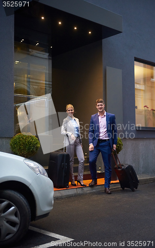 Image of business people couple entering  hotel