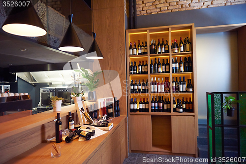 Image of Wine bottles on a wooden shelf.