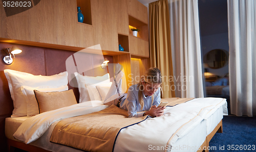Image of young business woman relaxing in hotel room