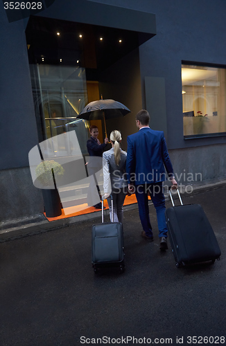 Image of business people couple entering  hotel