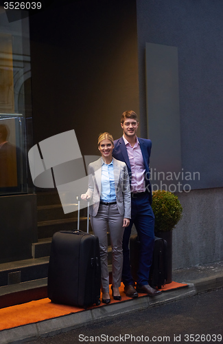 Image of business people couple entering  hotel