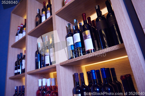 Image of Wine bottles on a wooden shelf.