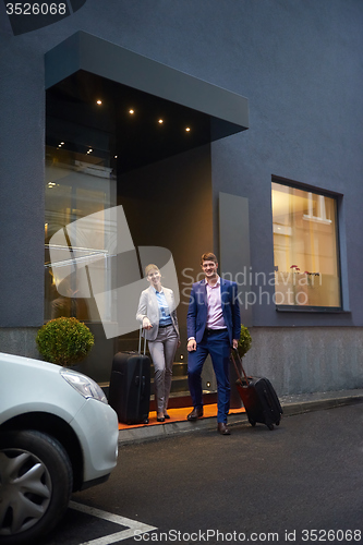 Image of business people couple entering  hotel