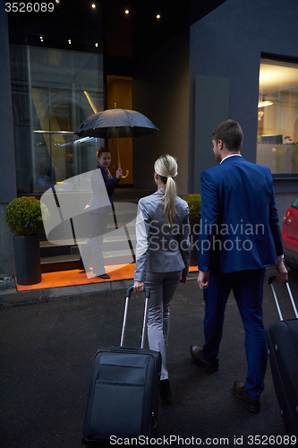 Image of business people couple entering  hotel