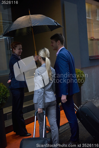 Image of business people couple entering  hotel