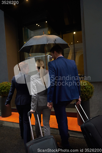 Image of business people couple entering  hotel