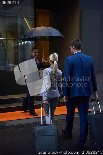 Image of business people couple entering  hotel