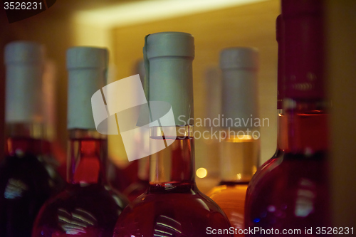 Image of Wine bottles on a wooden shelf.