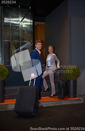 Image of business people couple entering  hotel