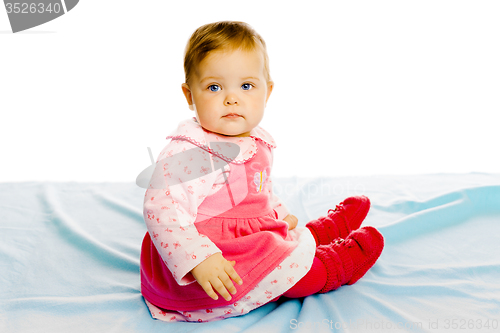 Image of Beautiful baby sitting on a blue blanket. Studio