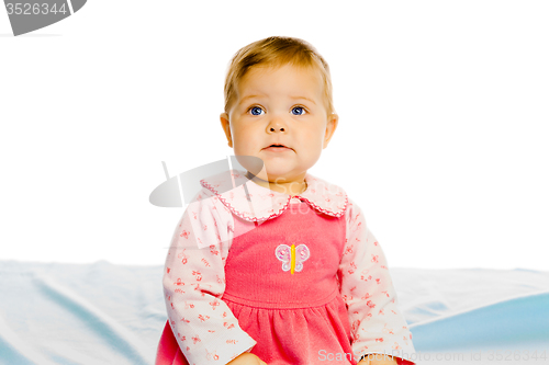 Image of Beautiful baby sitting on a blue blanket. Studio