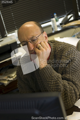 Image of man looking at computer screen in office
