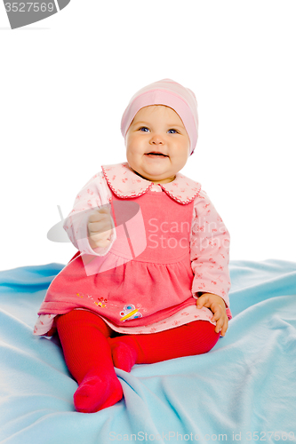 Image of Beautiful baby sitting on a blue blanket. Studio