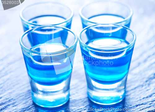 Image of blue alcoholic drink into small glasses