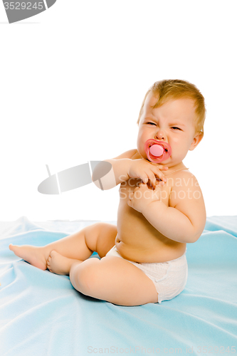 Image of upset baby in diapers. Studio