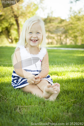 Image of Cute Little Girl Sitting and Laughing in the Grass