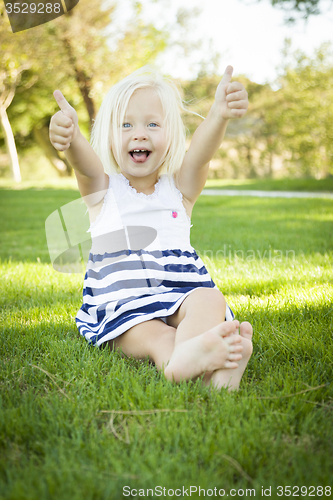 Image of Cute Little Girl with Thumbs Up in the Grass
