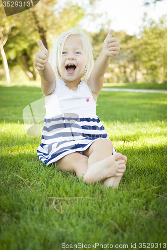 Image of Cute Little Girl with Thumbs Up in the Grass