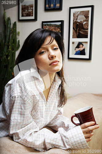 Image of young woman is having her morning tea