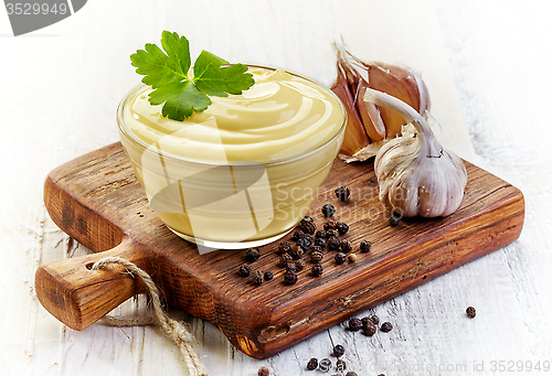 Image of Mayonnaise sauce on wooden cutting board