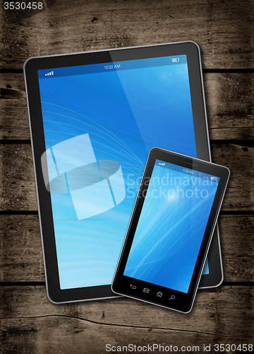 Image of Smartphone and digital tablet PC on a dark wood table