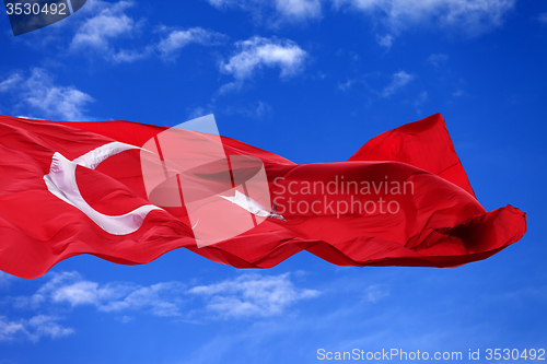 Image of Waving flag of Turkey against blue sky