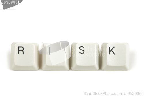 Image of risk from scattered keyboard keys on white