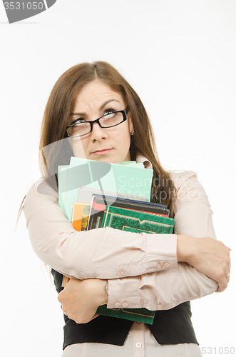 Image of Thoughtful teacher with textbooks and notebooks