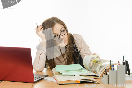 Image of Master delves into the book, checking a notebook students