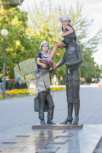 Image of Two girls on the monument to the first teacher