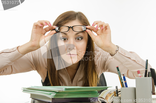 Image of The teacher stares at the pile of notebooks