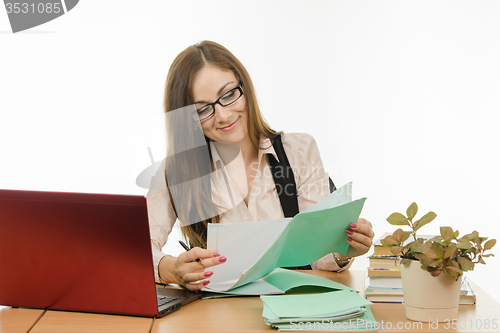 Image of The teacher checks the student notebook