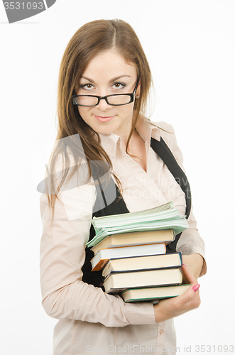 Image of Portrait of a teacher with a heap of textbooks and notebooks