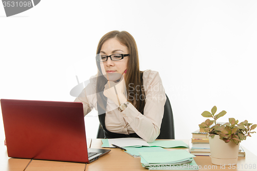 Image of The teacher with glasses working on a laptop